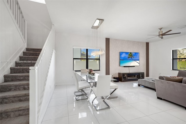 living room featuring ceiling fan with notable chandelier and light tile patterned floors