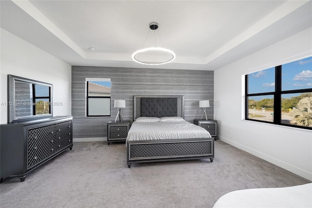 bedroom with a raised ceiling and carpet