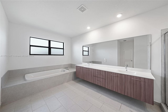 bathroom with tile patterned flooring, separate shower and tub, and vanity