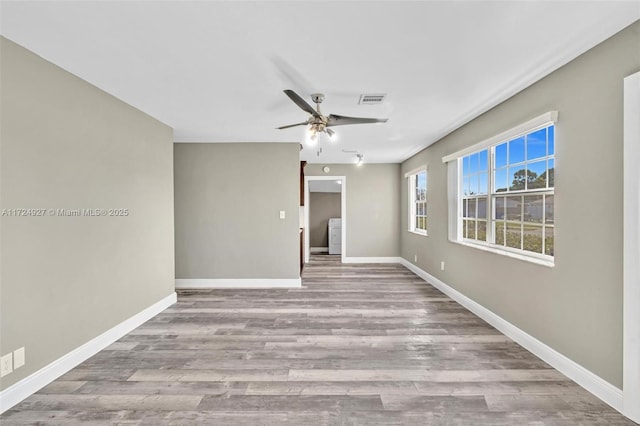 empty room with ceiling fan and light hardwood / wood-style floors