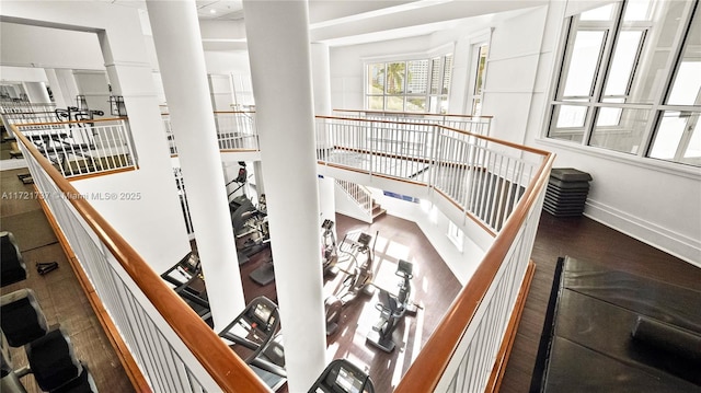 stairway featuring a towering ceiling and hardwood / wood-style flooring