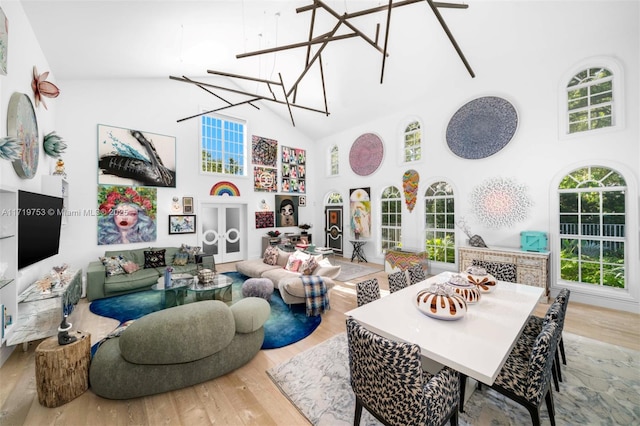 interior space with high vaulted ceiling, a chandelier, and wood-type flooring