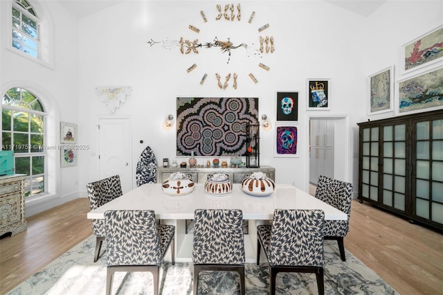 dining room with a high ceiling and light hardwood / wood-style flooring