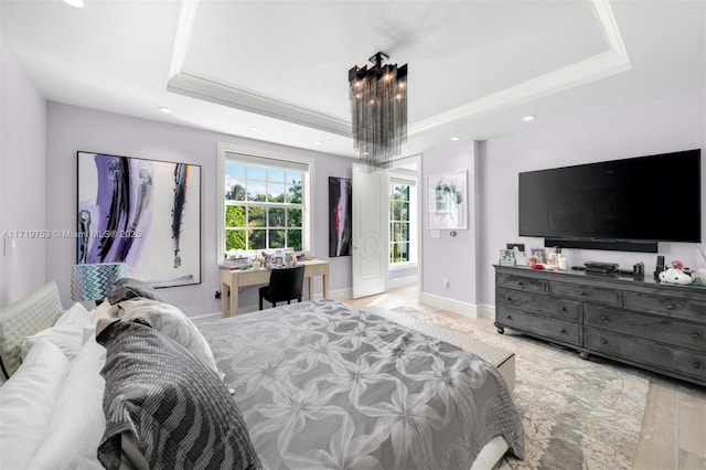 bedroom featuring light wood-type flooring, a tray ceiling, crown molding, and a chandelier