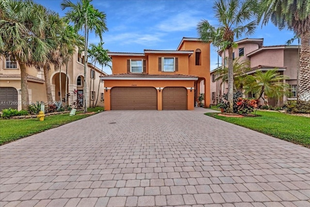 mediterranean / spanish-style home with a front yard and a garage