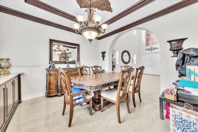 dining room with ornamental molding and an inviting chandelier