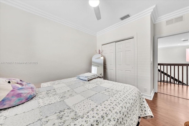 bedroom with ceiling fan, a closet, ornamental molding, and hardwood / wood-style flooring