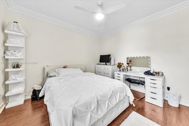 bedroom featuring ceiling fan, ornamental molding, and dark hardwood / wood-style floors