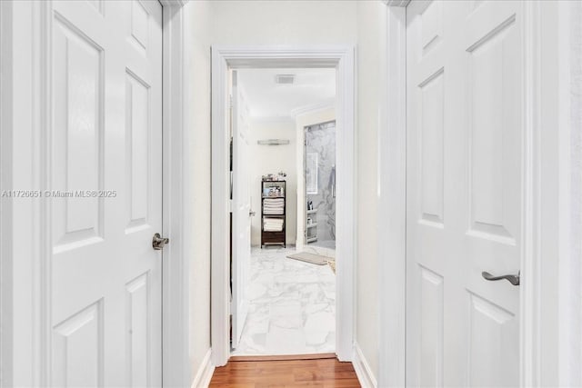 hall with hardwood / wood-style floors and crown molding