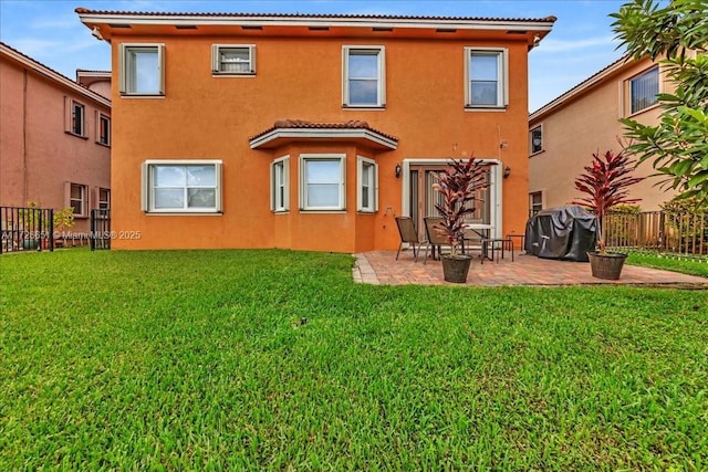 back of property with a yard and a patio area