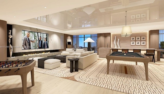 playroom featuring a high ceiling, pool table, and light hardwood / wood-style flooring