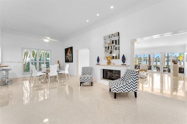 living room featuring a towering ceiling, ornamental molding, french doors, and ceiling fan