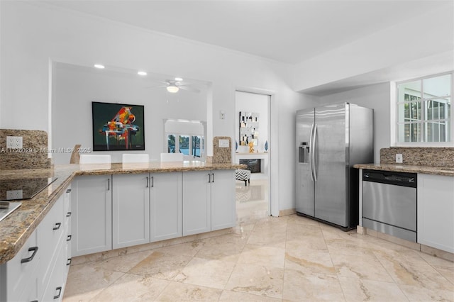 kitchen featuring white cabinetry, light stone counters, ceiling fan, kitchen peninsula, and appliances with stainless steel finishes