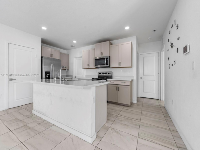 kitchen with appliances with stainless steel finishes, sink, and a kitchen island with sink