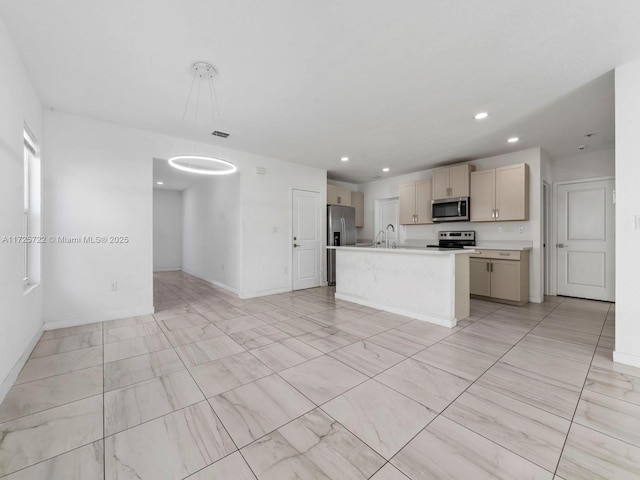 kitchen featuring sink, hanging light fixtures, light brown cabinets, appliances with stainless steel finishes, and an island with sink