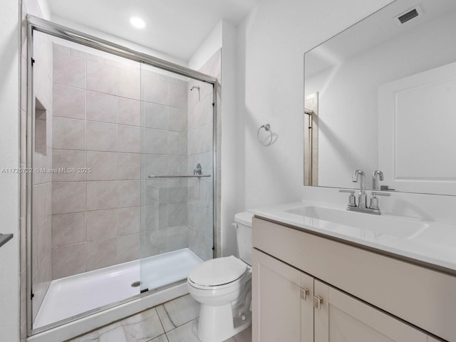 bathroom featuring vanity, toilet, and a shower with door