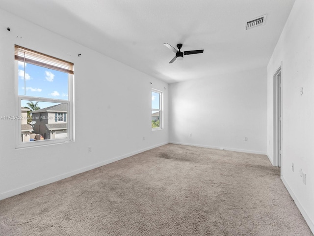 empty room with ceiling fan and light colored carpet