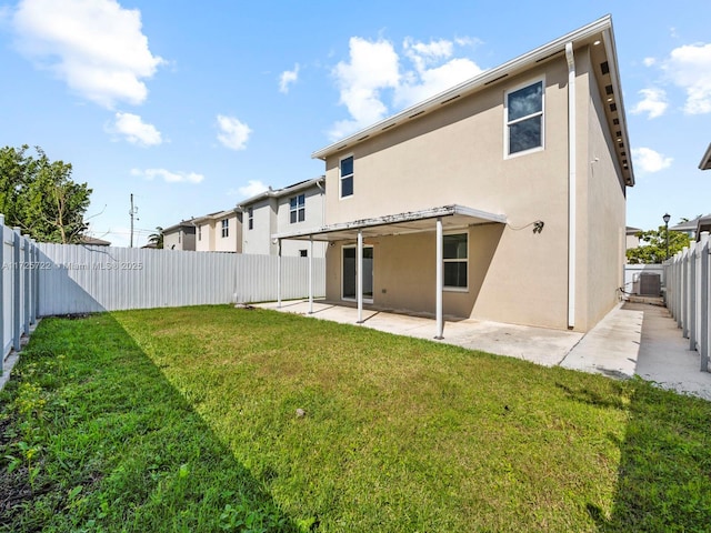 rear view of house with a yard and a patio