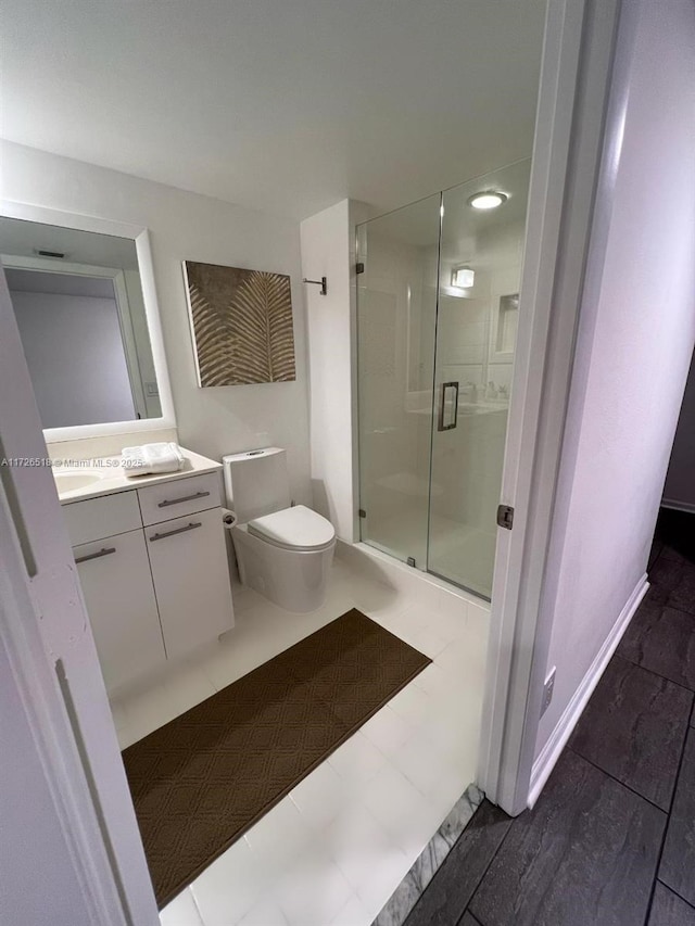 bathroom with vanity, a shower with shower door, and toilet