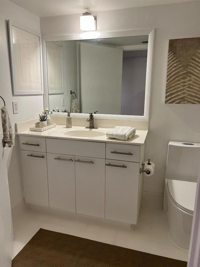 bathroom with toilet, tile patterned flooring, and vanity