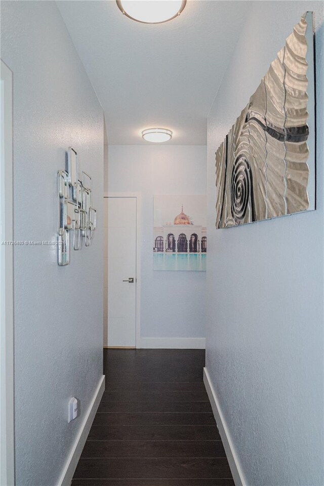 hallway with dark hardwood / wood-style flooring