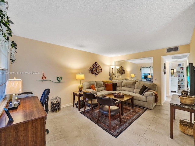 living room with a textured ceiling and light tile patterned floors