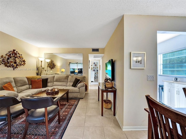 living room with a textured ceiling and light tile patterned floors