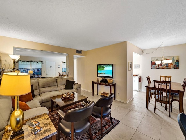 living room featuring a textured ceiling, an inviting chandelier, and light tile patterned floors