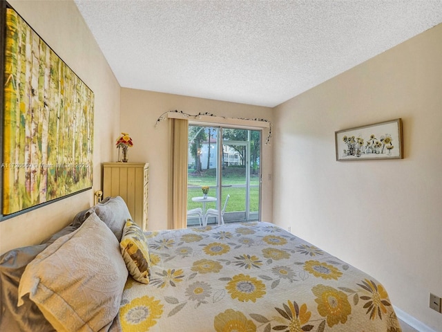 bedroom with access to exterior and a textured ceiling