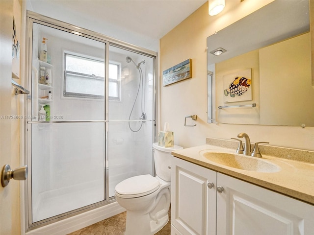 bathroom with toilet, tile patterned floors, a shower with shower door, and vanity