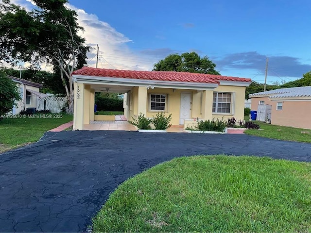 mediterranean / spanish-style house with a front lawn and a carport