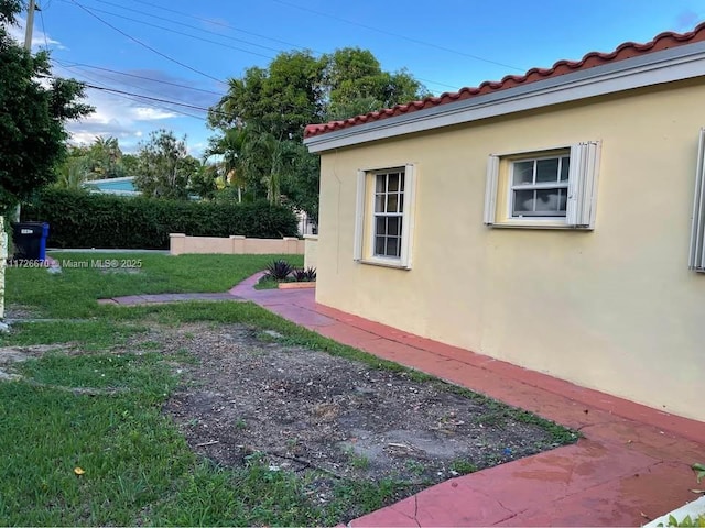 view of side of home with a lawn