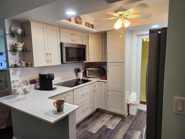 kitchen with white cabinetry, kitchen peninsula, stainless steel appliances, and dark hardwood / wood-style floors