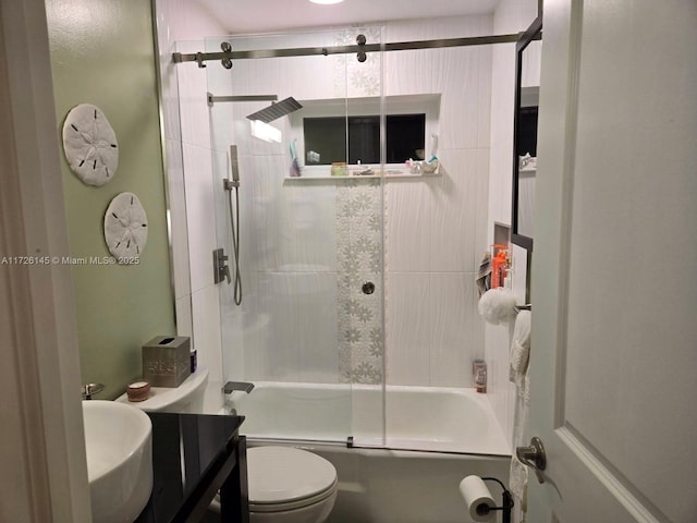 bathroom with toilet, vanity, and combined bath / shower with glass door