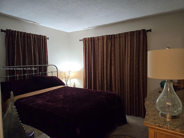 bedroom featuring carpet and a textured ceiling