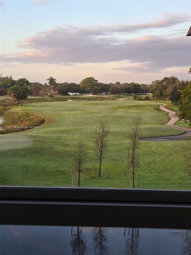 view of home's community with golf course view and a lawn