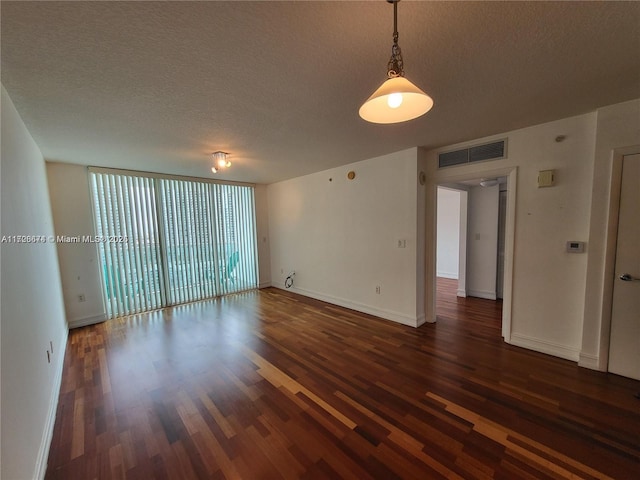 unfurnished room featuring dark hardwood / wood-style floors, floor to ceiling windows, and a textured ceiling