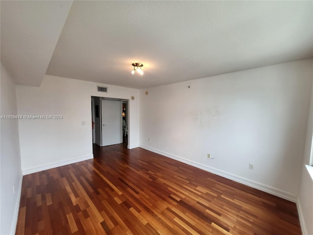 unfurnished room featuring dark wood-type flooring