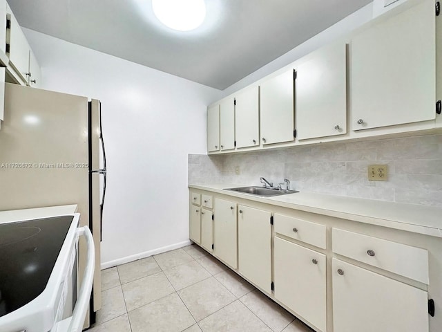 kitchen featuring light tile patterned floors, decorative backsplash, electric range oven, sink, and white cabinetry