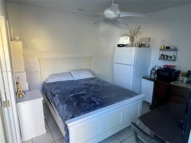 tiled bedroom with ceiling fan and white refrigerator