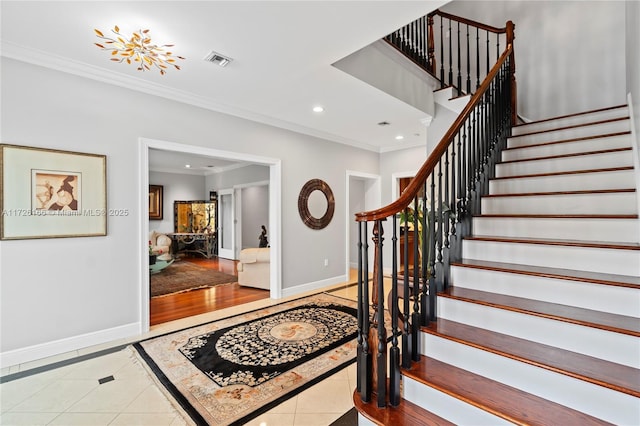 staircase with tile patterned floors and crown molding