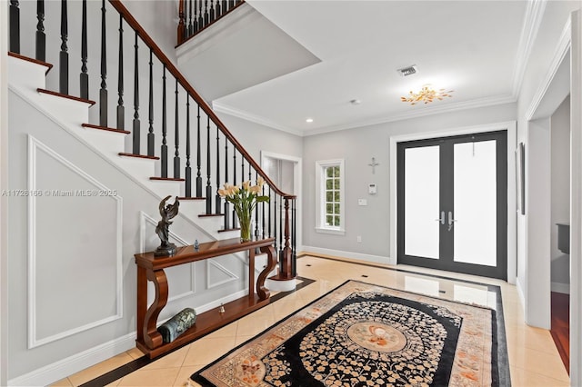 entrance foyer featuring ornamental molding, french doors, and light tile patterned floors