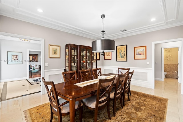 dining area featuring ornamental molding and light tile patterned floors