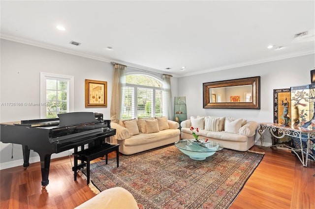 living room with a wealth of natural light, crown molding, and wood-type flooring