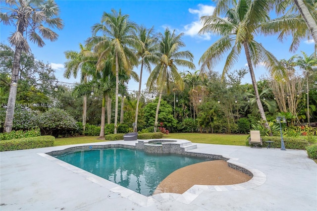 view of pool with a patio area, a yard, and an in ground hot tub