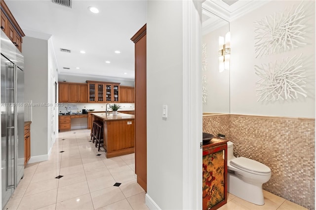 bathroom featuring toilet, crown molding, and tile patterned floors