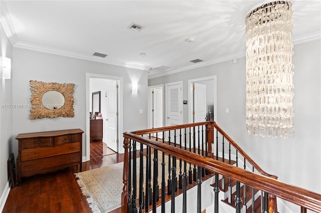 hall featuring an inviting chandelier, crown molding, and dark hardwood / wood-style floors