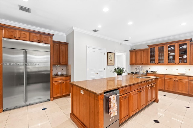 kitchen featuring stainless steel appliances, a kitchen island with sink, and crown molding