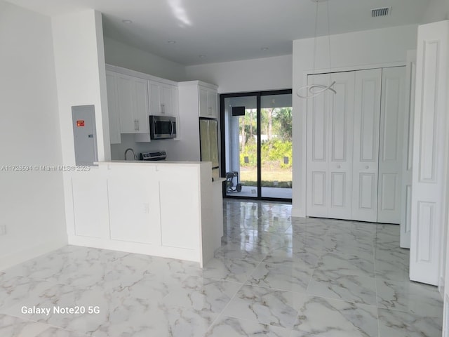 kitchen featuring white cabinetry, stainless steel appliances, kitchen peninsula, and electric panel