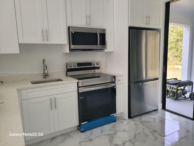 kitchen featuring stainless steel appliances, sink, and white cabinets